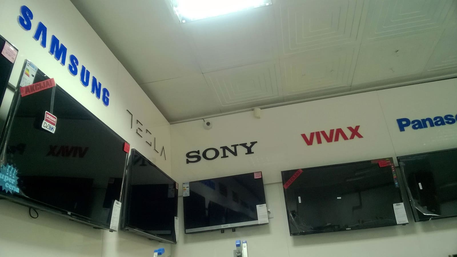 3D logotipi TV brendova u prodavnici (Samsung, Tesla, Sony)